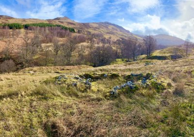 ruins of a foundation of an old stone cottage in a high glen in the Scottish Highlands