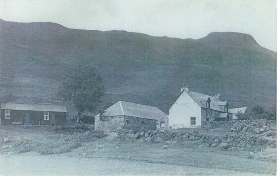 black and white photo of a 19th century Highland Scottish farm with a mountain the background